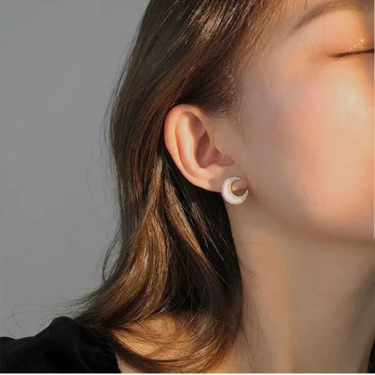 Pendientes de botón con forma de luna engastados con diamantes y concha.