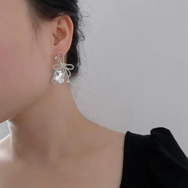 Aretes de perno de plata con diamantes de baguette y circonitas en forma de lazo