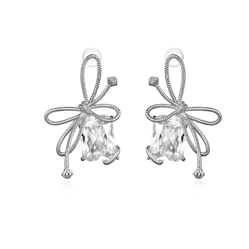 Aretes de perno de plata con diamantes de baguette y circonitas en forma de lazo