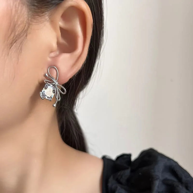 Aretes de perno de plata con diamantes de baguette y circonitas en forma de lazo