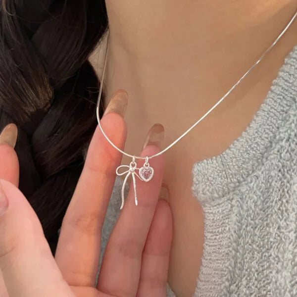 Collar con colgante de lazo de plata de ley 925 con corazón de diamantes rosas