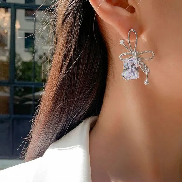 Aretes de perno de plata con diamantes de baguette y circonitas en forma de lazo