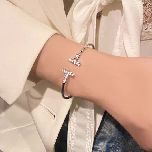 Pulsera abierta con doble T y detalles de circonia