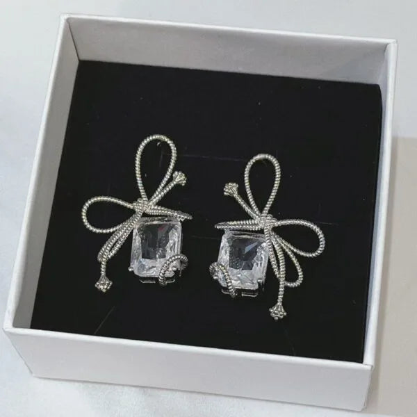 Aretes de perno de plata con diamantes de baguette y circonitas en forma de lazo